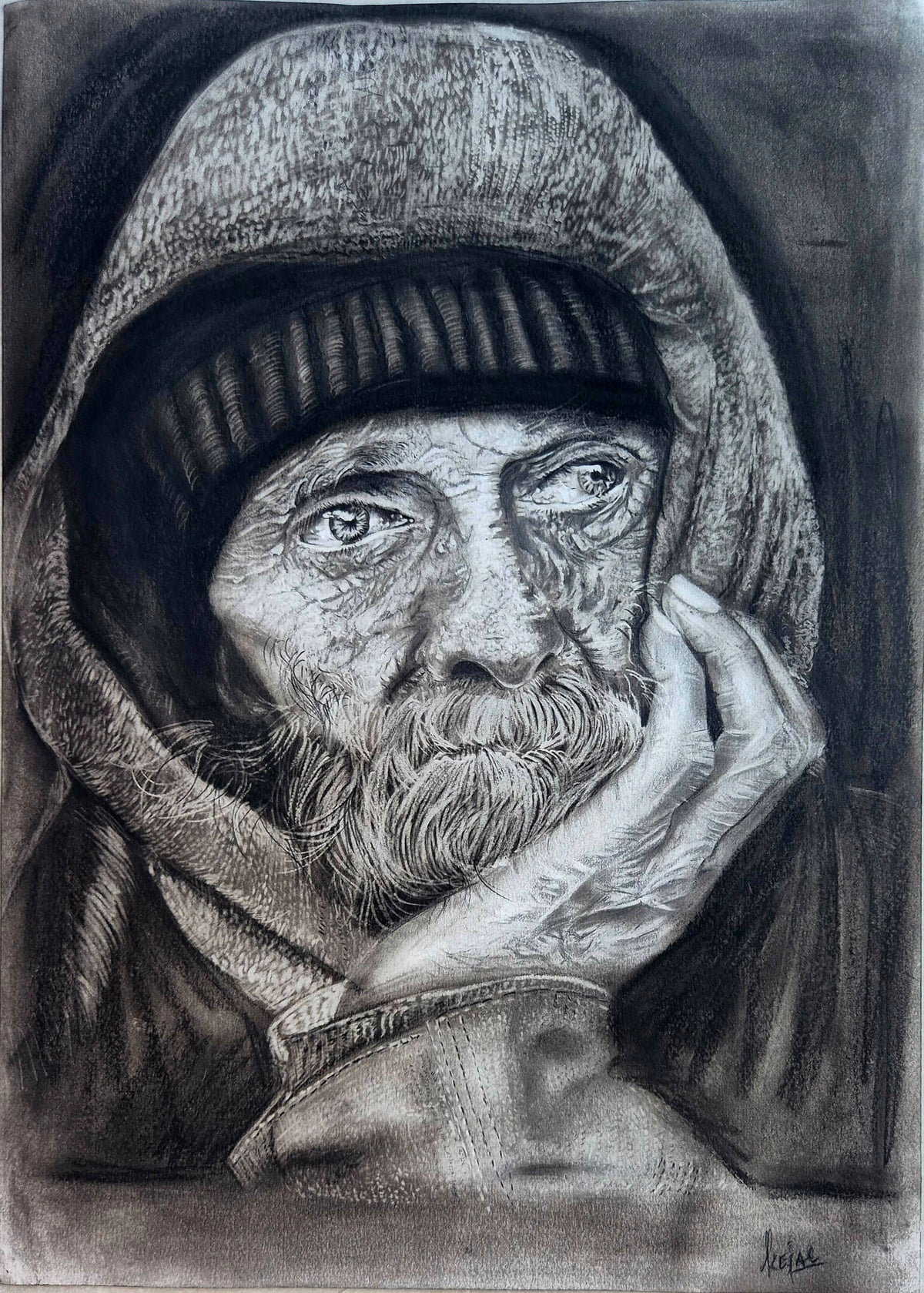 Charcoal portrait of a bearded older man in a knitted cap and hood, resting his chin on his hand